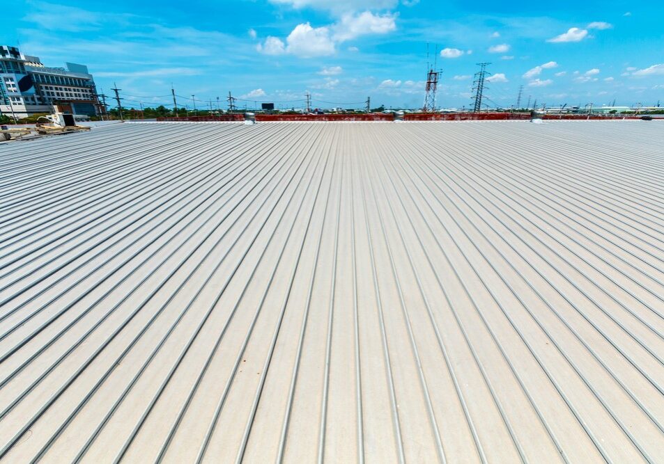 Corrugated metal industrial roof with turbine ventilators under a clear blue sky